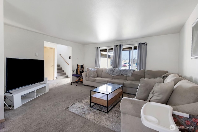 carpeted living area featuring stairs