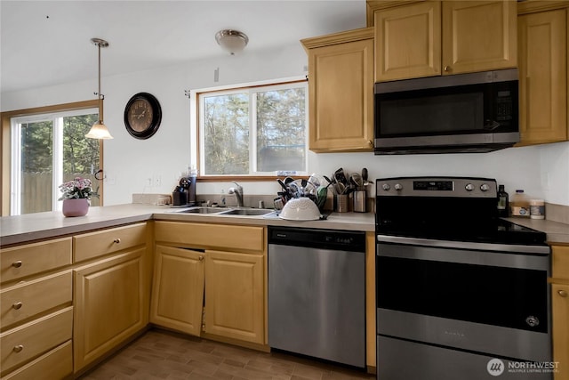 kitchen with light brown cabinets, appliances with stainless steel finishes, light countertops, and a sink