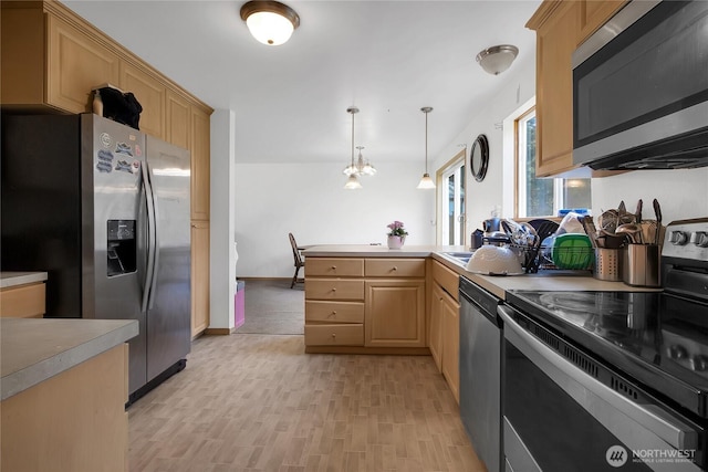 kitchen featuring light brown cabinets, a peninsula, hanging light fixtures, appliances with stainless steel finishes, and light countertops