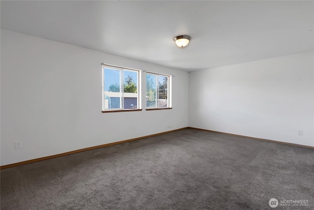 unfurnished room featuring carpet and baseboards