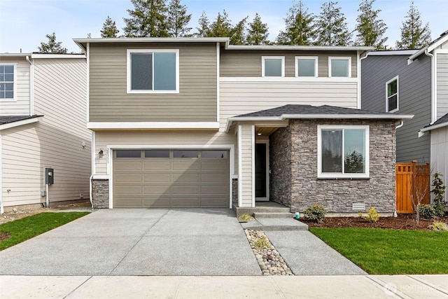 view of front of home featuring stone siding, an attached garage, concrete driveway, and fence