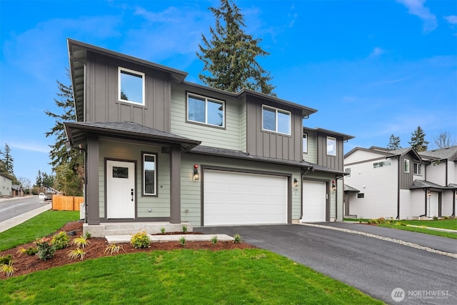 view of front of house with a garage, a residential view, board and batten siding, and aphalt driveway