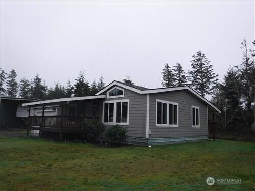 rear view of property featuring a lawn