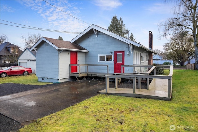 view of front of property featuring a deck, a chimney, and a front yard