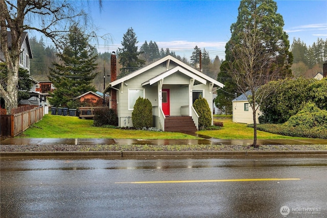 bungalow-style house featuring a front yard and fence