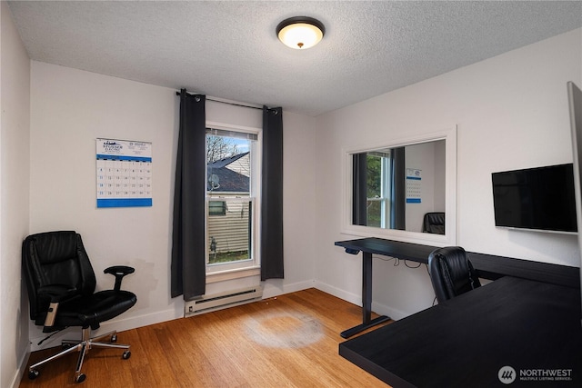 home office featuring a baseboard radiator, a textured ceiling, baseboards, and wood finished floors