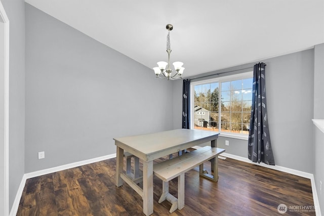 dining space with a chandelier, wood finished floors, and baseboards