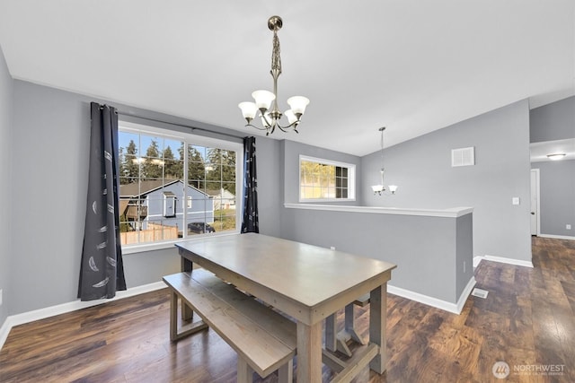 dining space featuring baseboards, wood finished floors, visible vents, and a notable chandelier