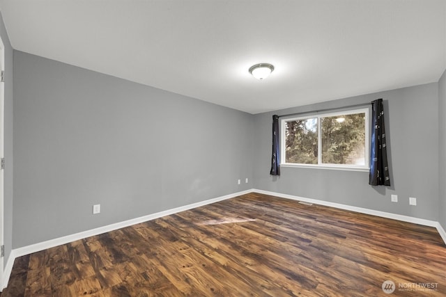 empty room with baseboards and dark wood finished floors