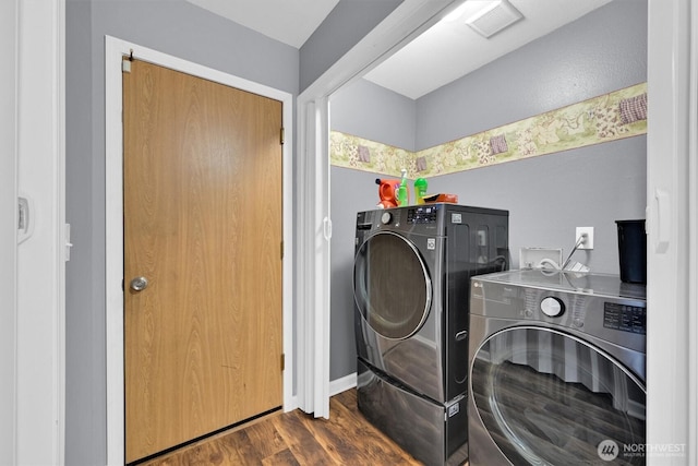 washroom with visible vents, washer and dryer, and wood finished floors