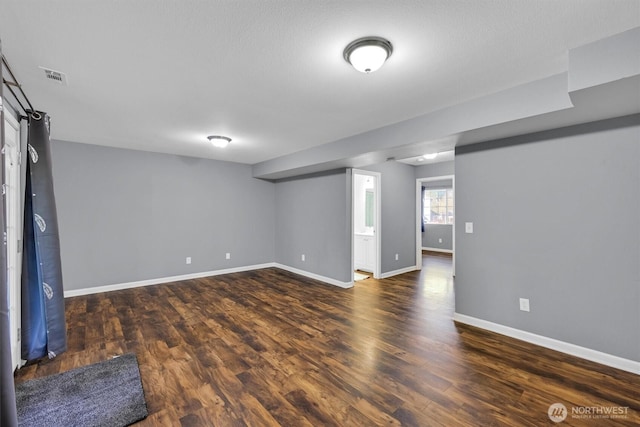 unfurnished room featuring wood finished floors, visible vents, and baseboards