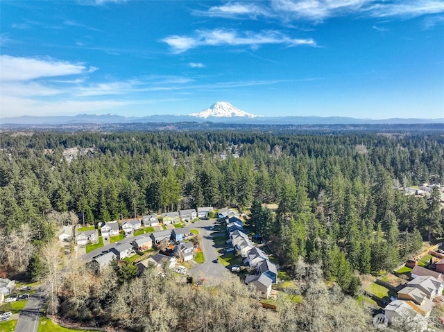 birds eye view of property featuring a residential view, a mountain view, and a wooded view