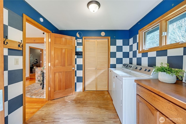 laundry room with light wood-type flooring and washing machine and dryer