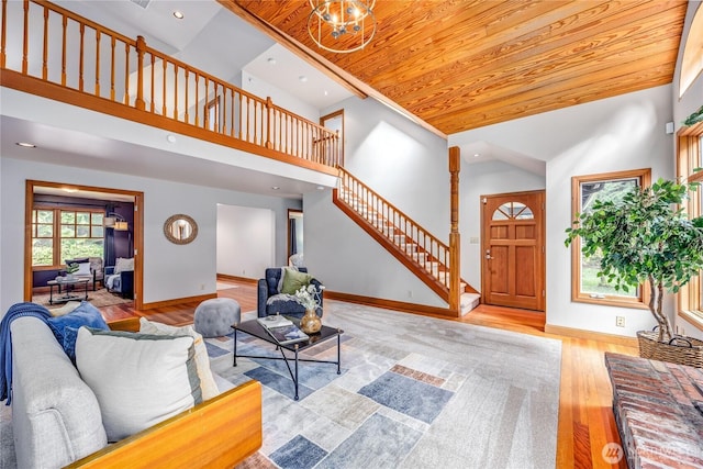 living room with wood finished floors, wood ceiling, baseboards, and stairs