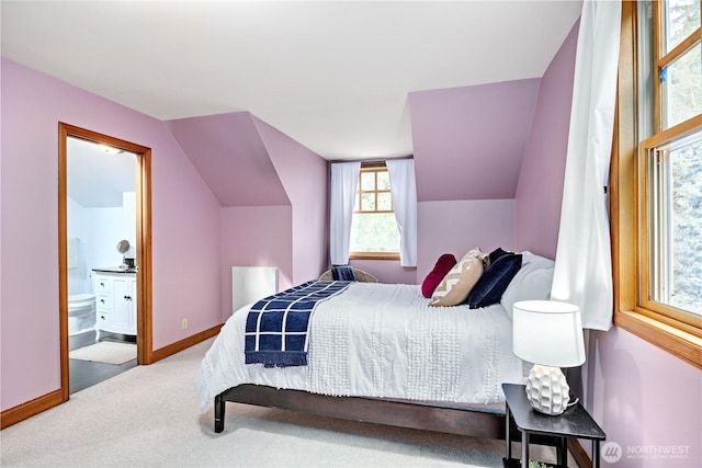 bedroom featuring lofted ceiling, carpet floors, baseboards, and connected bathroom