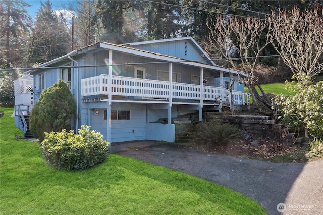 view of front facade featuring aphalt driveway, stairway, and a front lawn