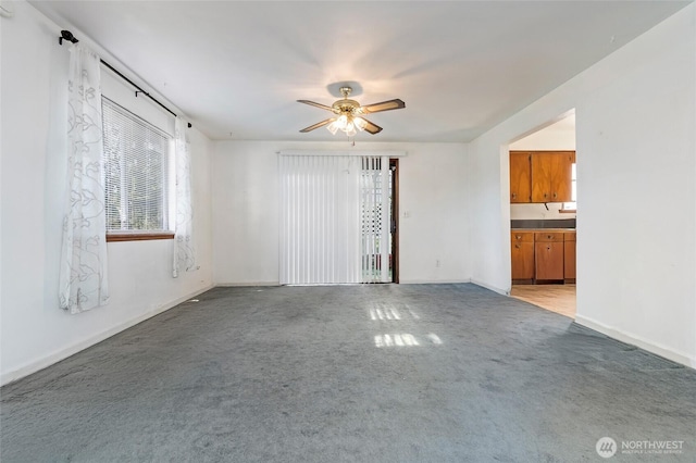 unfurnished living room with a ceiling fan and light colored carpet