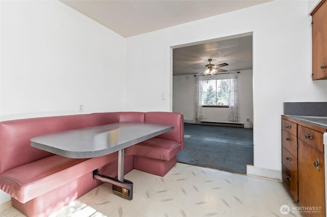 dining room featuring light carpet, a baseboard heating unit, ceiling fan, and breakfast area