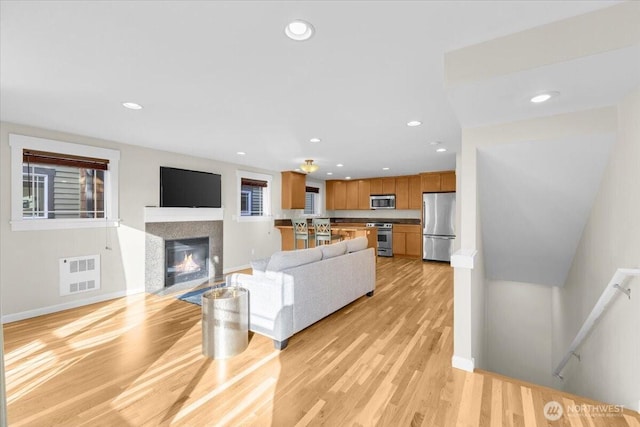 living room featuring light wood-style floors, visible vents, and recessed lighting