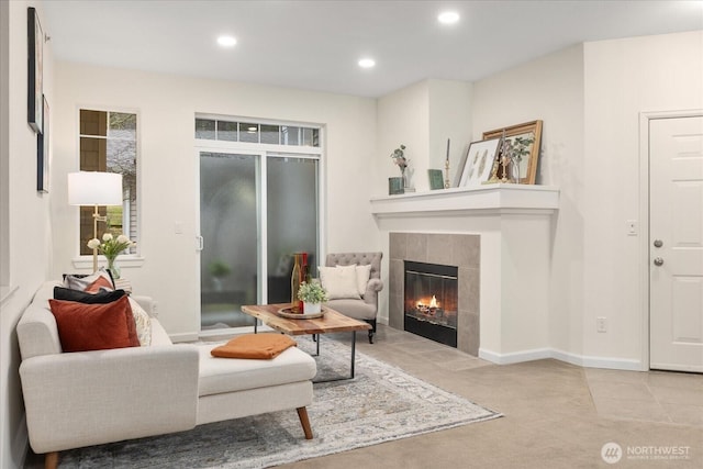 living area with carpet floors, recessed lighting, baseboards, and a tile fireplace