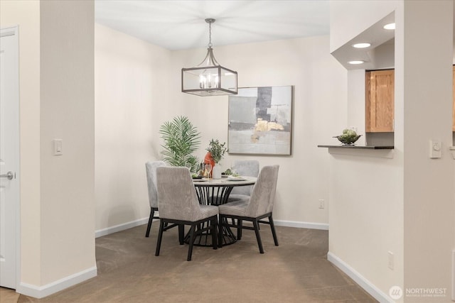 dining room with carpet floors, an inviting chandelier, and baseboards