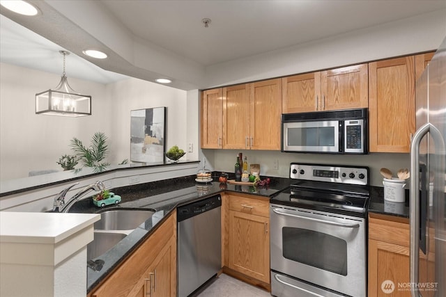 kitchen with stainless steel appliances, recessed lighting, hanging light fixtures, a sink, and a peninsula