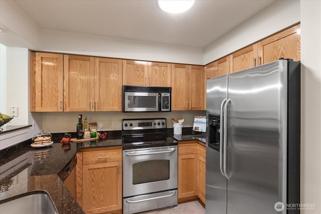 kitchen featuring dark stone counters and stainless steel appliances