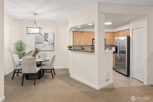 dining area with light carpet, baseboards, visible vents, and a chandelier