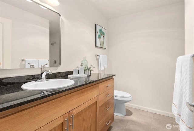 bathroom featuring baseboards, vanity, toilet, and tile patterned floors