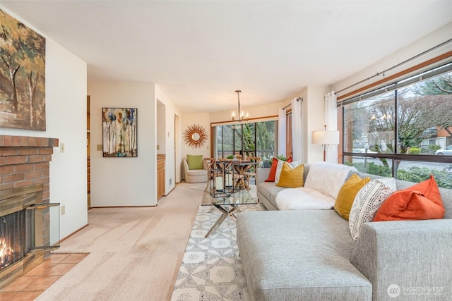 living room with light carpet, a brick fireplace, baseboards, and an inviting chandelier