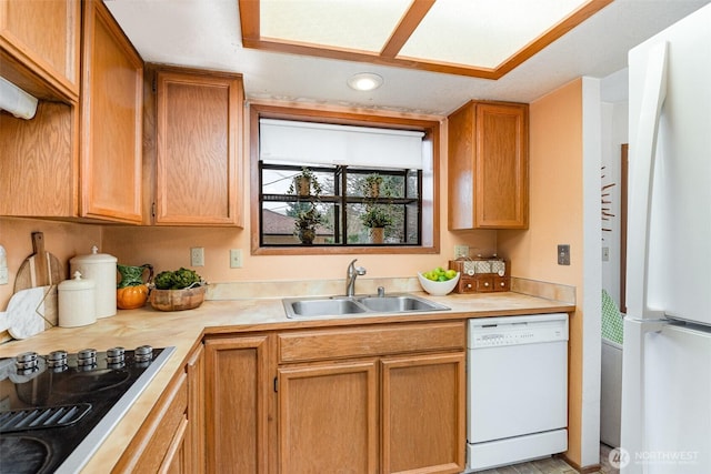 kitchen with white appliances, light countertops, and a sink