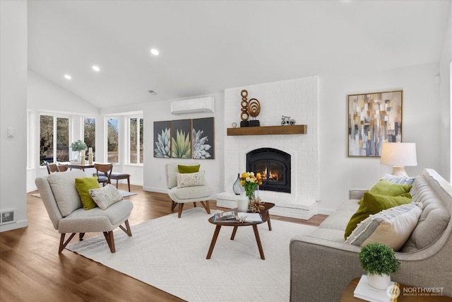 living area featuring recessed lighting, wood finished floors, visible vents, an AC wall unit, and a brick fireplace