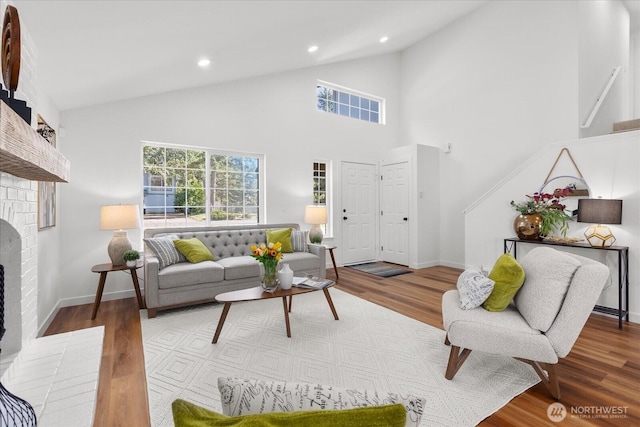 living room with recessed lighting, a brick fireplace, baseboards, and wood finished floors