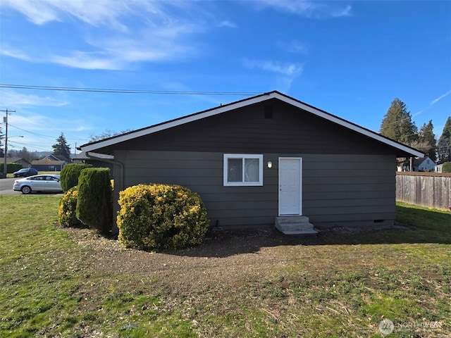 back of house featuring entry steps, a yard, crawl space, and fence