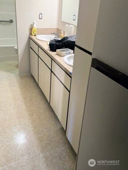 full bathroom with tile patterned floors, a sink, and double vanity