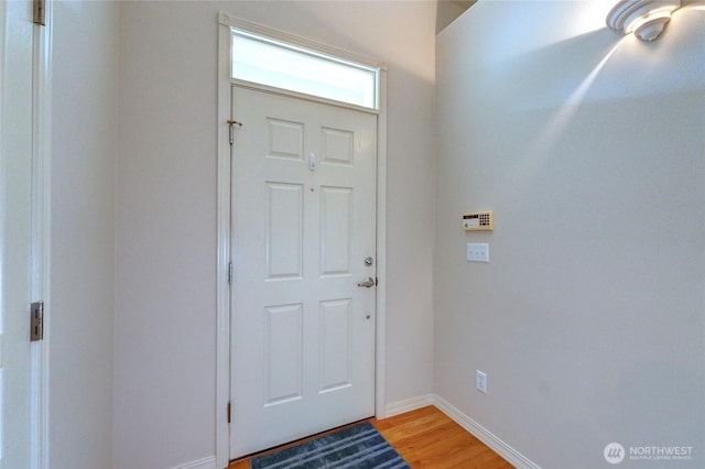 foyer entrance featuring baseboards and light wood finished floors