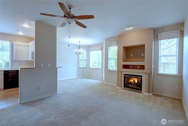 unfurnished living room with visible vents, plenty of natural light, light colored carpet, and a tiled fireplace