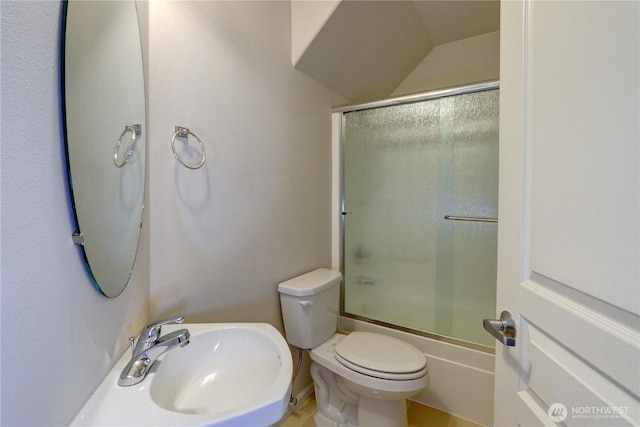 bathroom featuring a sink, enclosed tub / shower combo, and toilet