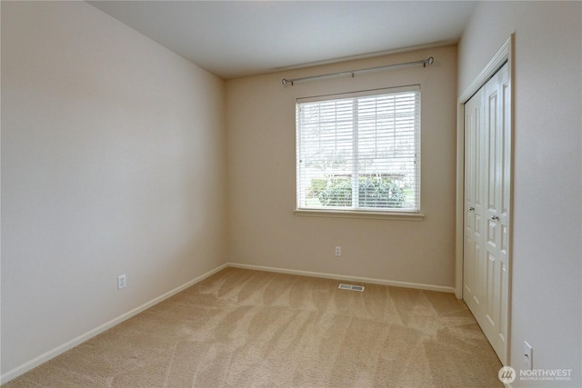 unfurnished bedroom featuring a closet, visible vents, baseboards, and carpet