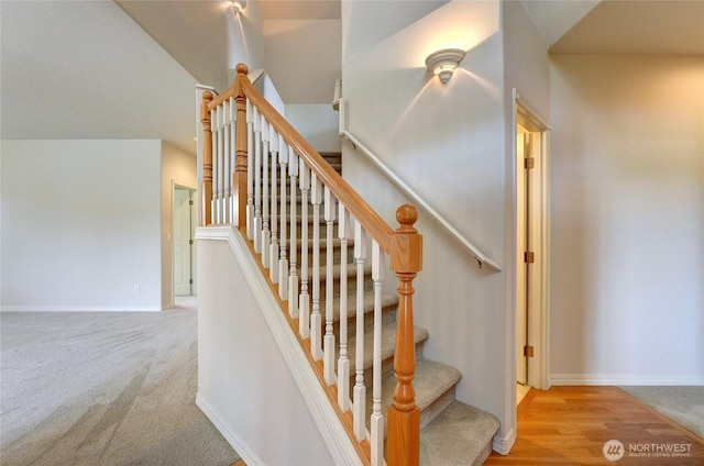 staircase with baseboards and carpet floors