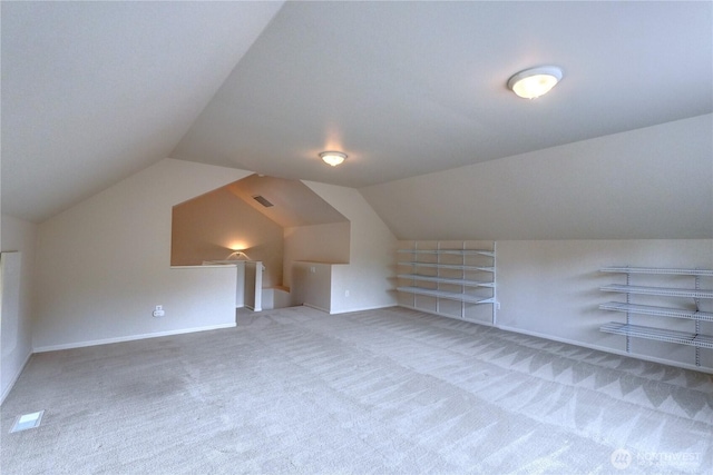 additional living space featuring vaulted ceiling, carpet, and baseboards