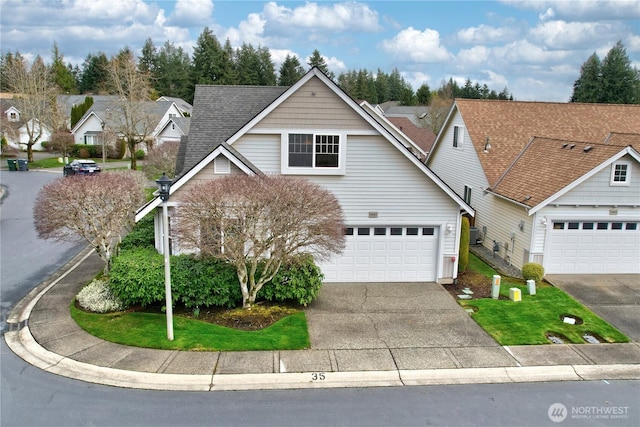 traditional home featuring driveway and a shingled roof