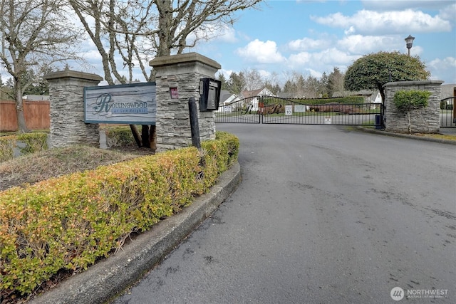 view of street featuring a gate, curbs, and a gated entry