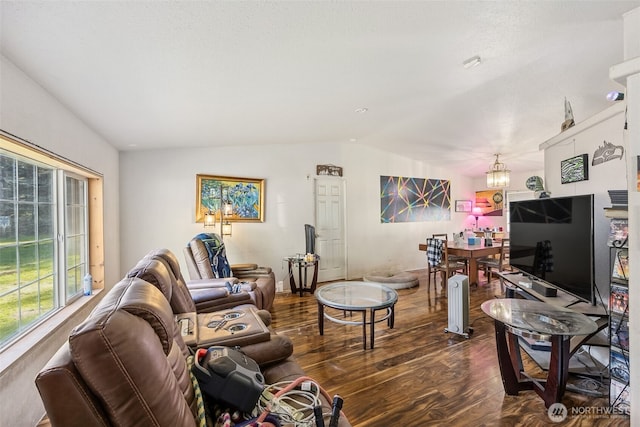 living room featuring lofted ceiling, a notable chandelier, and dark wood finished floors