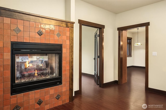 interior details featuring a multi sided fireplace, wood finished floors, and baseboards