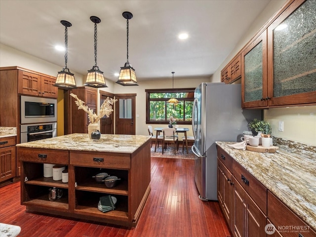 kitchen featuring light stone counters, dark wood-style flooring, appliances with stainless steel finishes, brown cabinets, and open shelves