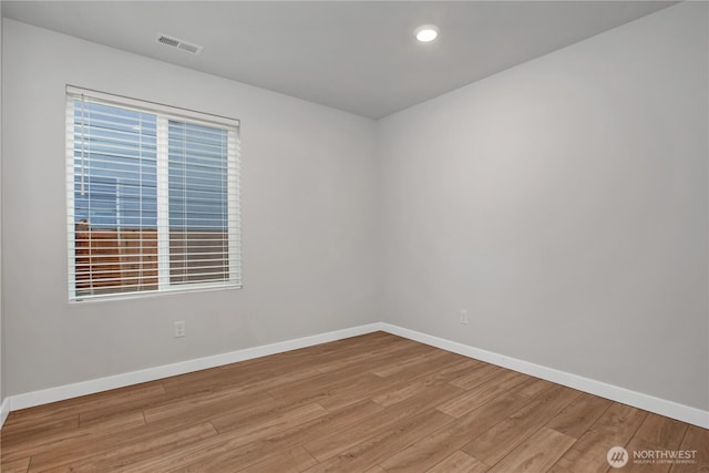 spare room featuring recessed lighting, wood finished floors, visible vents, baseboards, and a wealth of natural light