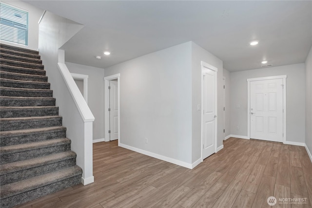 interior space with baseboards, wood finished floors, and recessed lighting