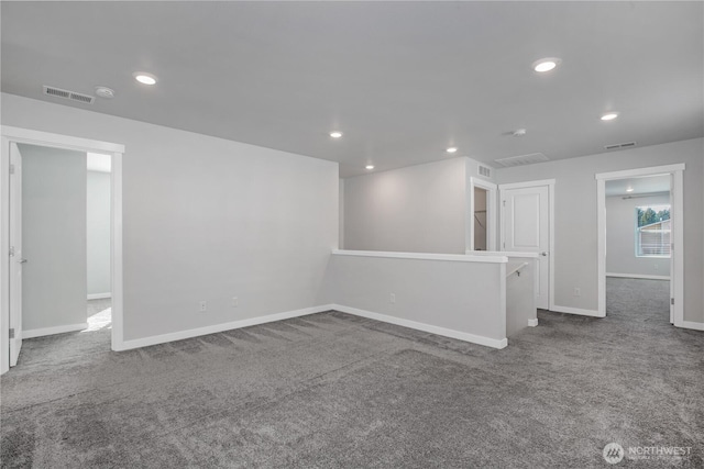 carpeted empty room with baseboards, visible vents, and recessed lighting