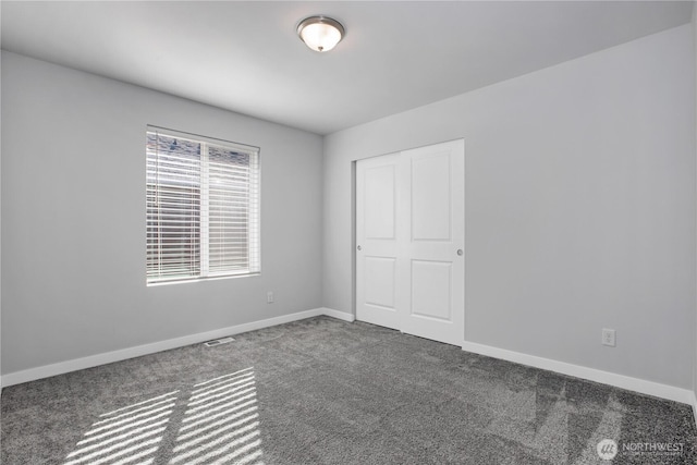 unfurnished bedroom featuring carpet floors, a closet, visible vents, and baseboards